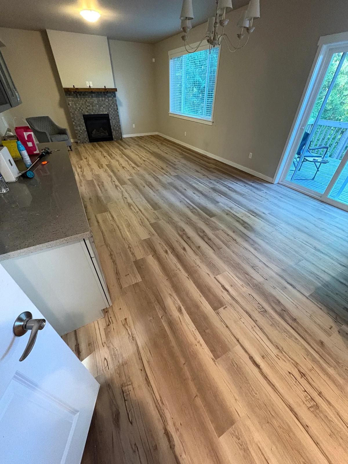 Dark laminate replaced with light wood-look LVP in the living area., after